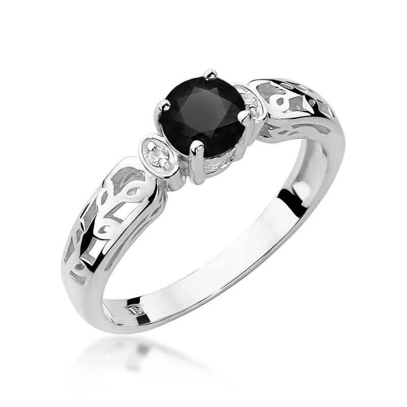 Žiedo centre spindi 0.5 ct juodasis deimantas, kuris suteikia šiam papuošalui drąsos ir modernumo. Jo tamsi, paslaptinga spalva puikiai dera su raudono aukso šiluma, sukuriant unikalų kontrastą. Aplink juodąjį deimantą išdėstyti briliantai prideda žvytėjimo ir elegancijos, suteikdami žiedui papildomo švytėjimo ir prabangos.