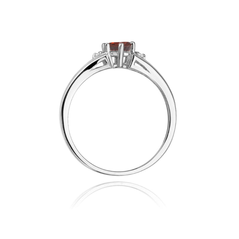 
                  
                    Šis žiedas – tai istorija apie meilę, aistrą ir nepavaldų laikui grožį. Jo centre – 0.6 ct granatas, lyg žėrintis ugnies lašas, kuris simbolizuoja stiprias emocijas, vidinę energiją ir gyvybingumą. Jį švelniai apkabina spindintys briliantai, suteikdami šviesos ir subtilaus žavesio.

Auksas – amžinas ir nesenstantis, kaip tikros emocijos. Jo šilta spalva sukuria tobulą dermę su granato gilumu, o švytintys briliantai prideda lengvumo ir elegancijos. Tai ne tik papuošalas – tai jausmas, prisiminimas, jaudinant
                  
                