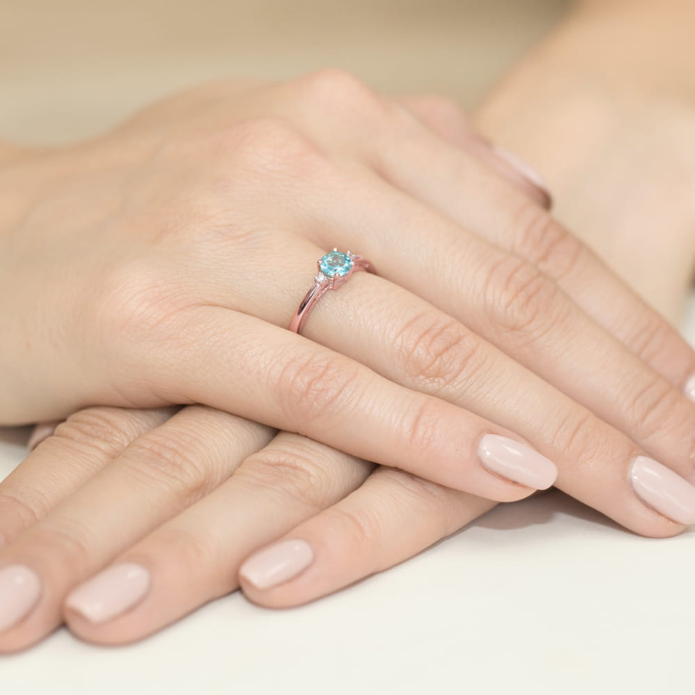 
                  
                    Raudono aukso žiedas su 0.5 ct topazu ir briliantais – elegancija, švelnumas ir subtilus prabangos prisilietimas.

Žiedo centre puikuojasi 0.5 ct natūralus topazas – skaidrus ir žavingas akmuo, dažniausiai žydros spalvos, simbolizuojantis vidinę ramybę, aiškumą ir harmoniją. Jo šviesus spindesys puikiai dera su 585 arba 750 prabos raudono aukso šiltu tonu, sukuriant romantišką ir jaukų derinį. Aplink topazą spindintys briliantai suteikia papildomo švytėjimo ir prabangos.
                  
                