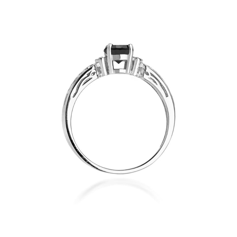 
                  
                    Žiedo centre spindi 0.5 ct juodasis deimantas, kuris suteikia šiam papuošalui drąsos ir modernumo. Jo tamsi, paslaptinga spalva puikiai dera su raudono aukso šiluma, sukuriant unikalų kontrastą. Aplink juodąjį deimantą išdėstyti briliantai prideda žvytėjimo ir elegancijos, suteikdami žiedui papildomo švytėjimo ir prabangos.
                  
                