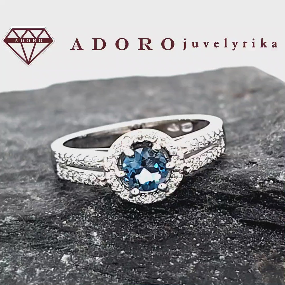 Baltas auksinis žiedas su Londono mėlynu topazu ir briliantų aureole – ADORO juvelyrika
