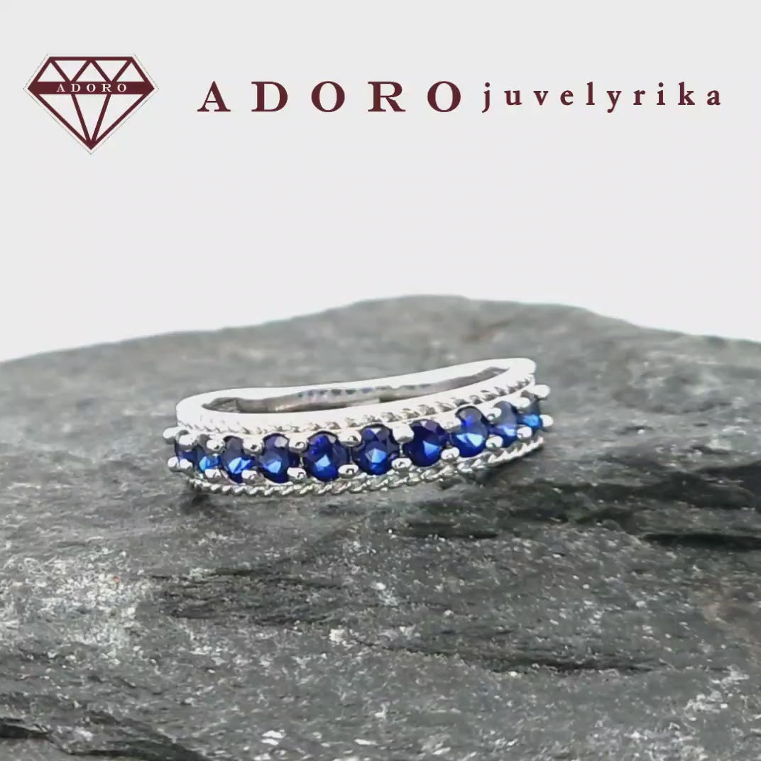 Elegantiškas balto aukso žiedas su 10 natūralių safyrų baltame fone – ADORO juvelyrika
